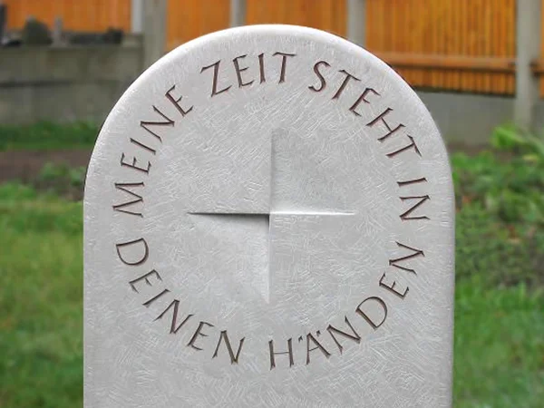 abgerundeter Grabstein mit Kompass und Spruch